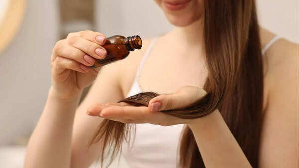Woman applying hair oil to her scalp