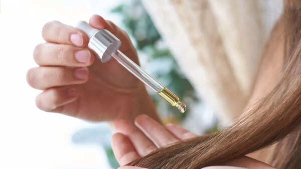 Woman applying hair serum